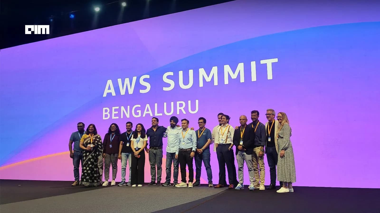 The AWS Summit Bengaluru stage with the organising team lined up in front of the main screen