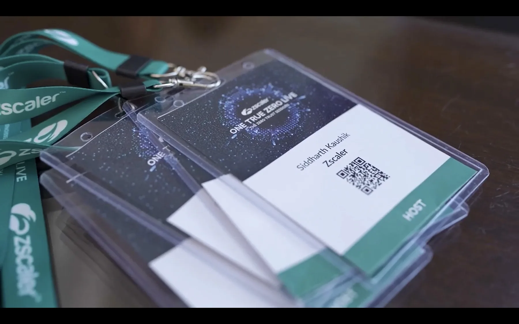 A stack of printed ZenithLive attendee badges with QR codes, ready on the registration desk